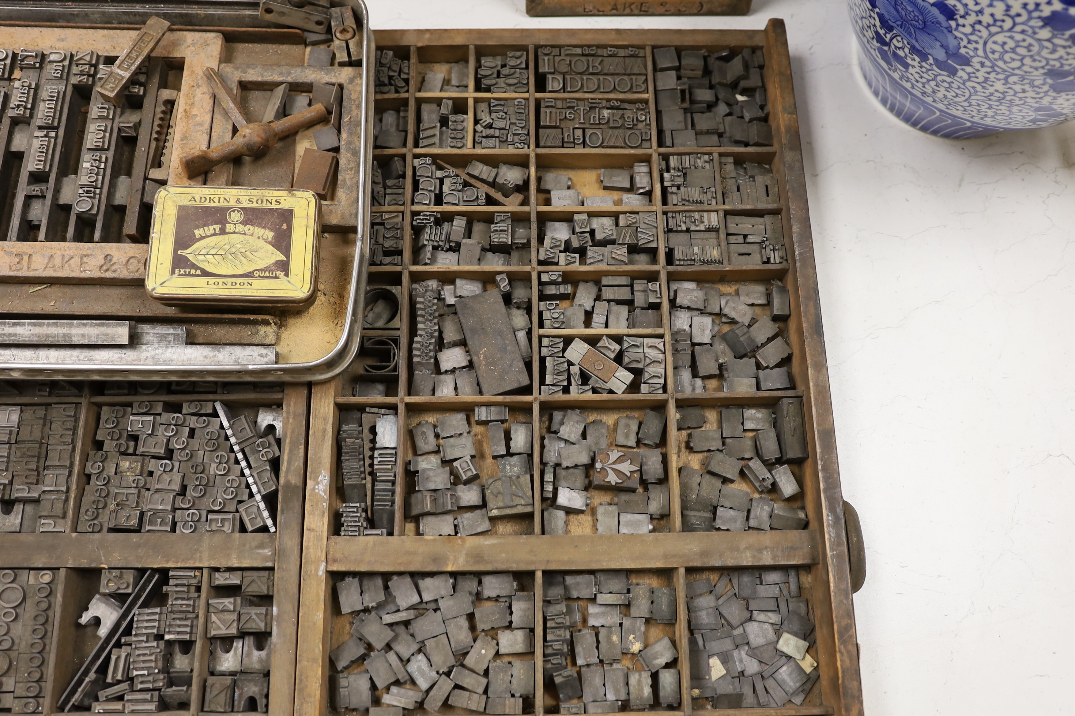 Three trays of metal printing type: chases, quoins and spacing bars